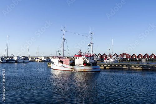 Laesoe / Denmark: A fishing cutter leaves the harbor of Vesteroe Havn photo