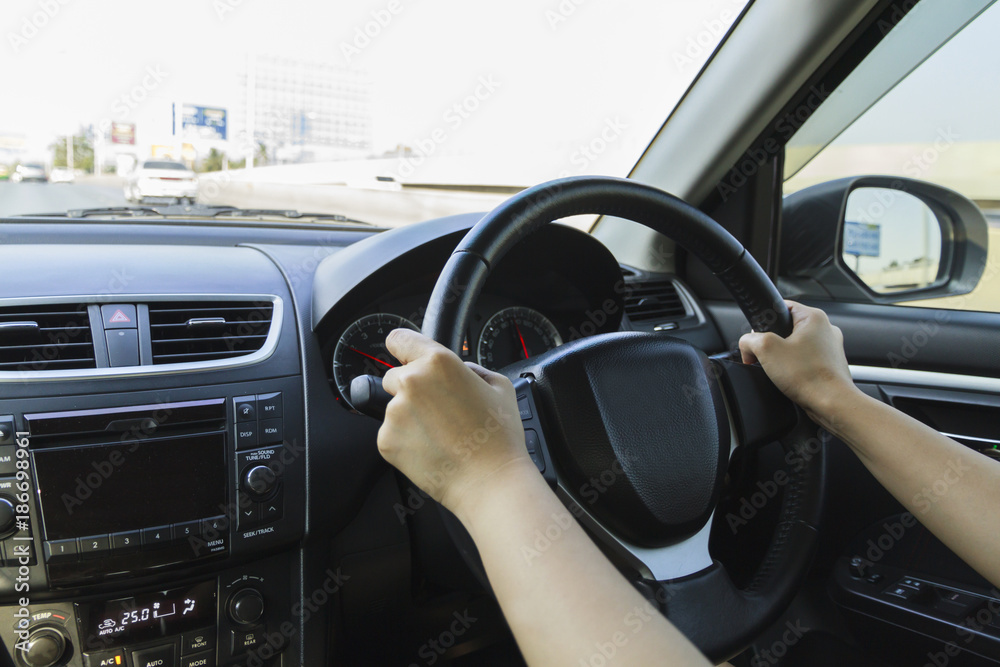 Driving car hands on steering wheel.