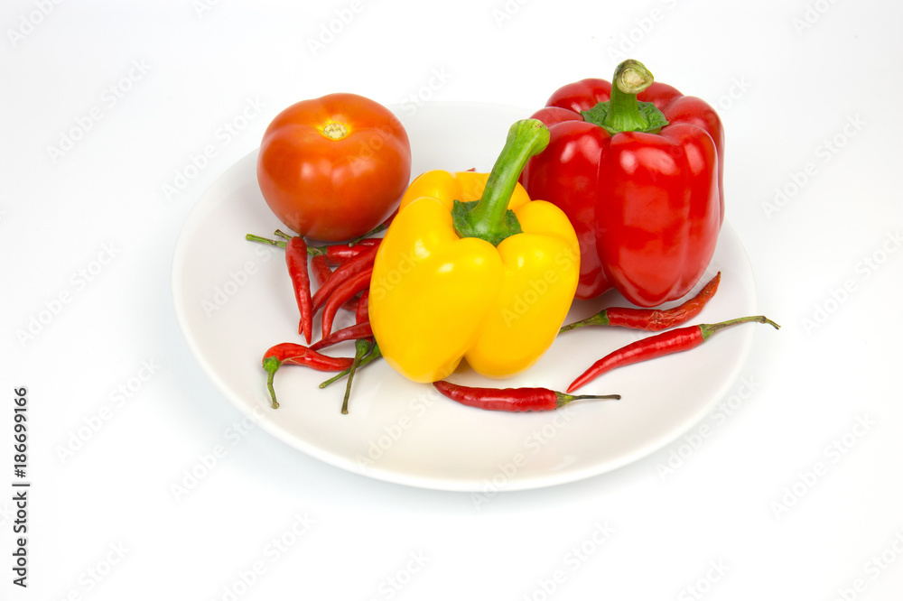 Paprika Paprika Yellow Paprika Red paprika and tomato on a white plate on a white backdrop. Paprika Paprika Yellow Paprika Red paprika and tomato on a white plate on a white backdrop.