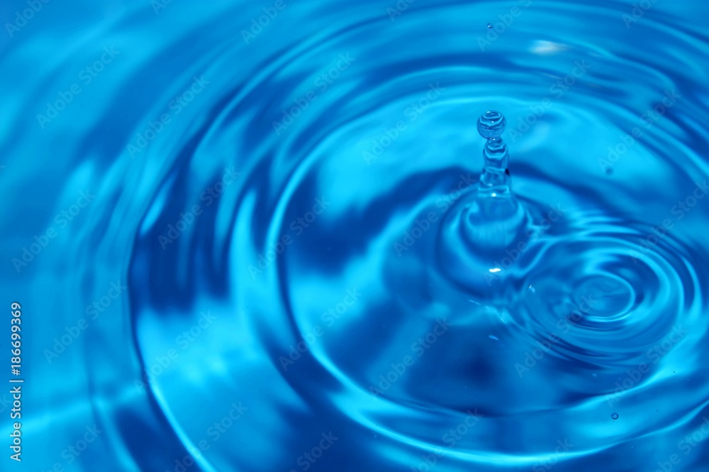 Beautiful shot of water drop hitting the water level Beautiful shot of water drop hitting the water level