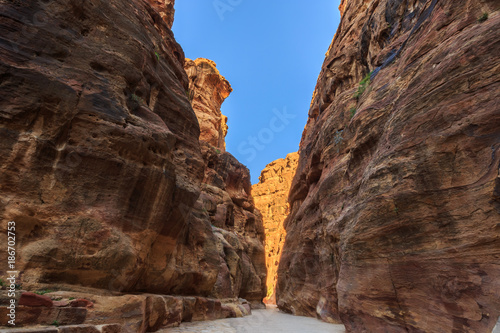 A narrow passage between steep rock formations in the siq at Petra the ancient City Al Khazneh in Jordan