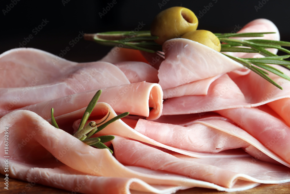 Sliced ham on wooden background. Fresh prosciutto. Pork ham sliced.