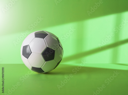 Soccer ball against on green background at morning sun Copy space.