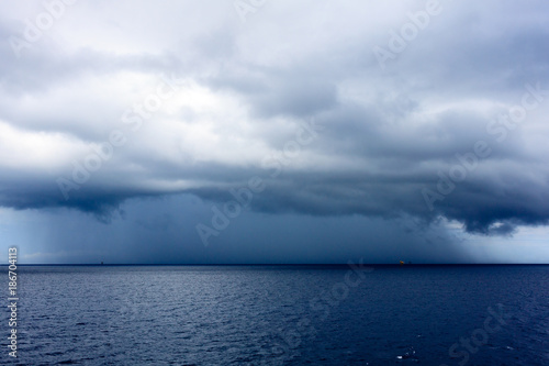 Daek blue sea color and storm raining cloud background.