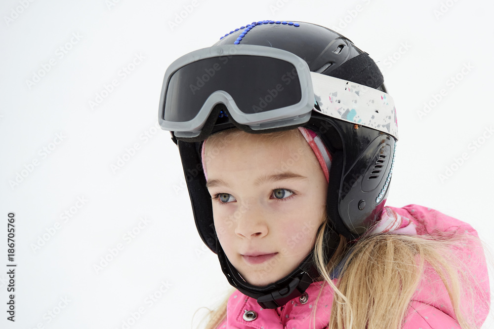Portrait of child skier girl in helmet and goggles in winter resort Portrait of child skier girl in helmet and goggles in winter resort