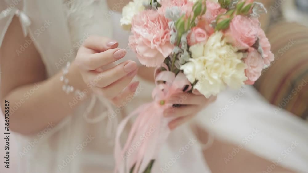 Wedding morning of the bride. A girl in her underwear and negligee admires her bouquet of roses Wedding morning of the bride. A girl in her underwear and negligee admires her bouquet of roses