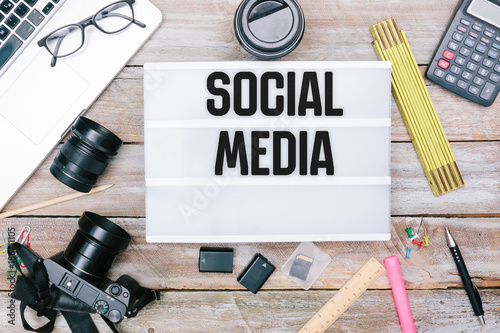 Social Media text in light box on office desk flat lay photo