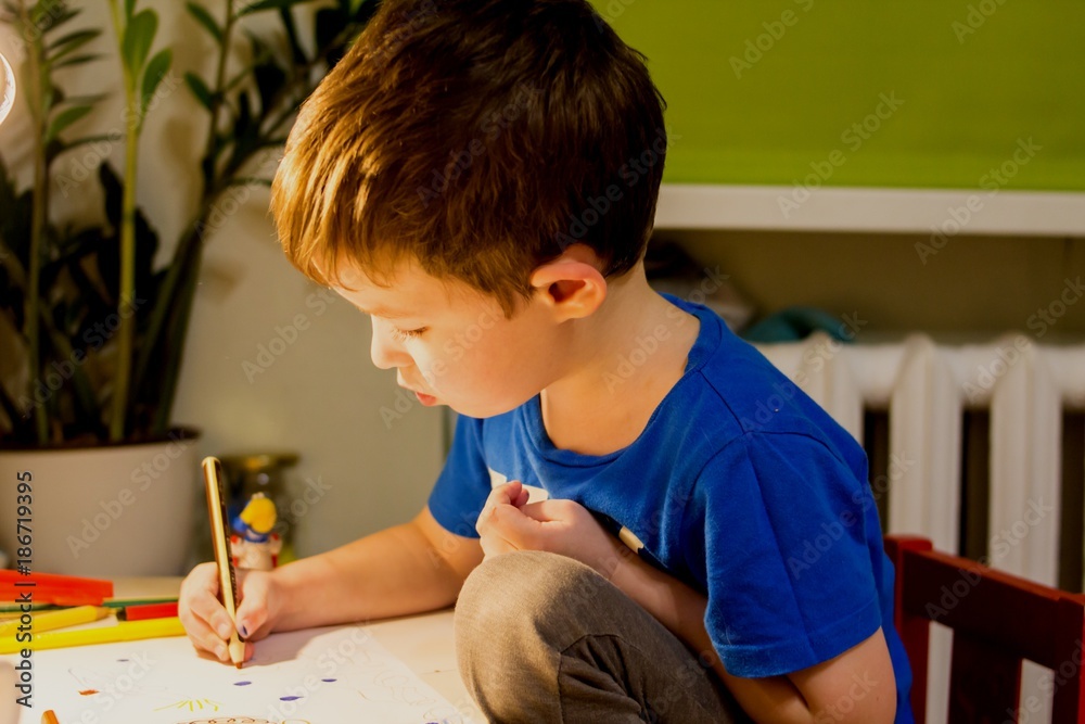 teenager drawing sitting at a children's table teenager drawing sitting at a children's table