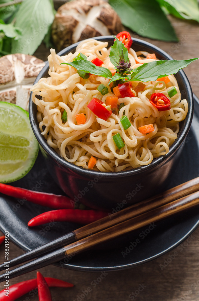 Instant noodles in black bowl on wooden background. Instant noodles in black bowl on wooden background.