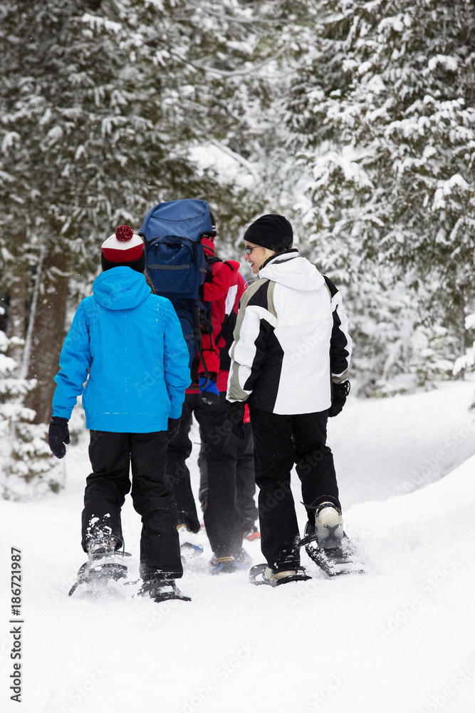 Family snowshoes in snow in Canada