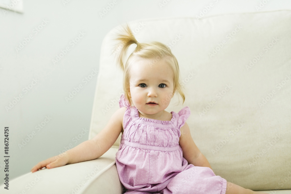 Portrait of cute baby girl sitting on sofa Portrait of cute baby girl sitting on sofa