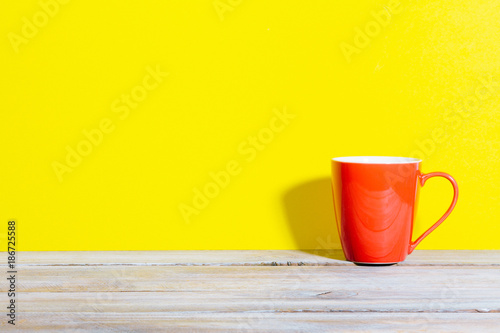 Bold colored red coffee mug on yellow background