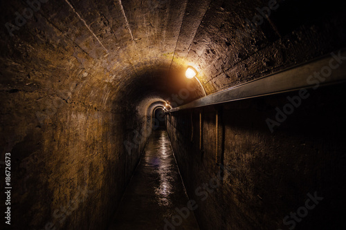 Dark corridor of old underground Soviet military bunker under artillery fortification.