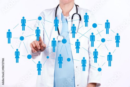 Arzt vor einer virtuellen Wand mit einem Netzwerk von Patienten photo