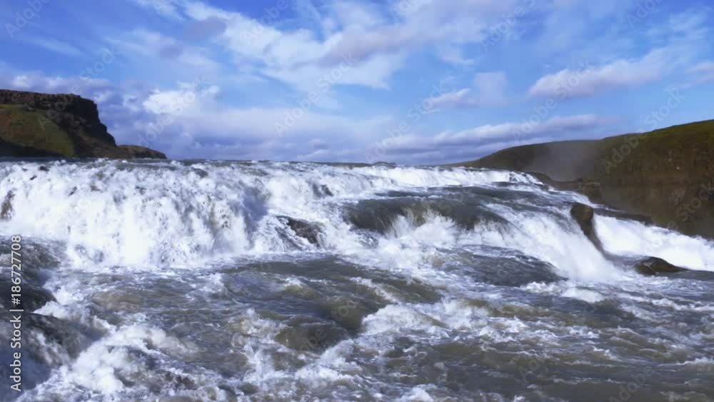 Iceland - famous waterfall Gullfoss. Summer day, water stream against blue sky.