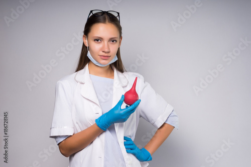 Young girl doctor with enema photo