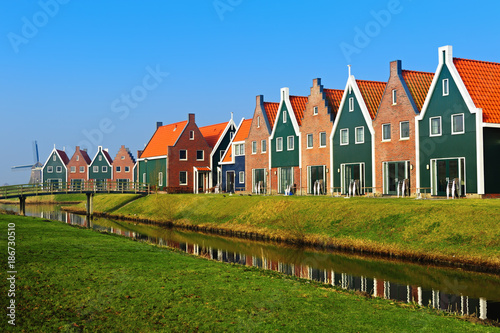 Colored houses of marine park in Volendam reflected in the water, The Netherlands