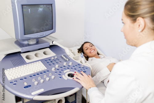 Pregnant young woman at gynecologist having examined with ultrasound device