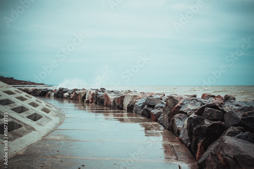 Rose waves during a storm in winter, waves break against rocks