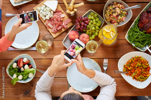 people with smartphones photographing food