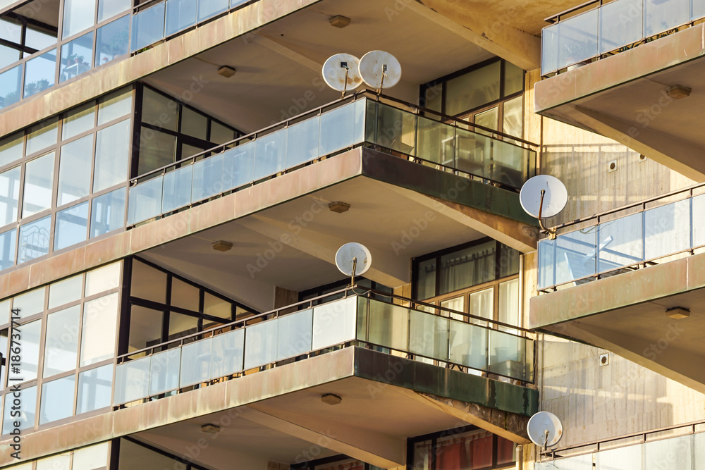 Fototapeta premium Facade of the reseidential building with windows and balconies and satelite antennas