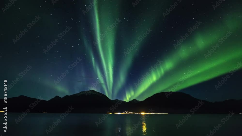 Pan right, northern lights timelapse above Norway fjord