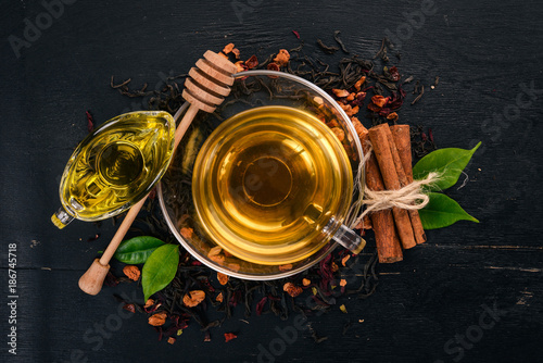 Tea in a cup of cinnamon and honey on a wooden background. Hot drink Top view. Copy space.
