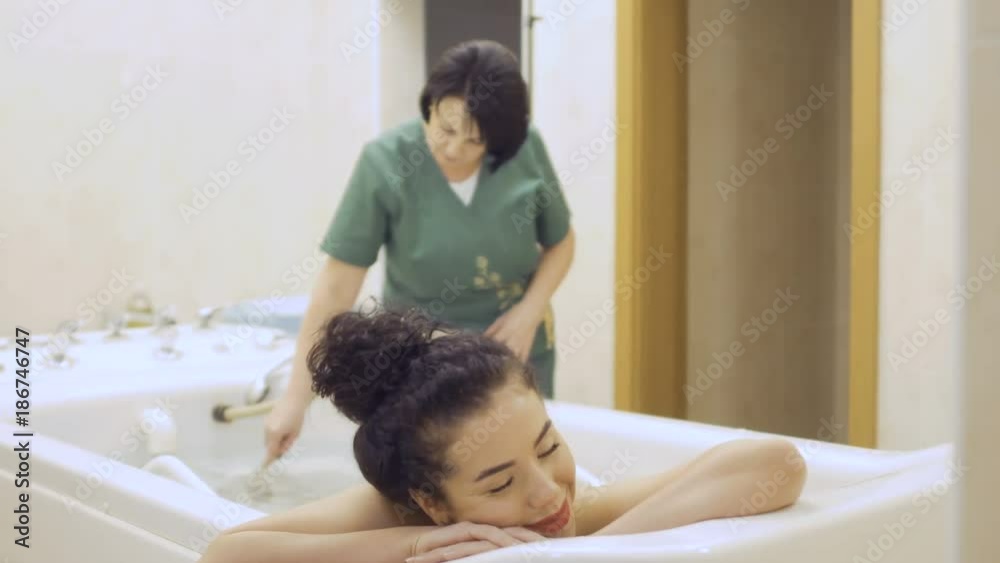 Attractive woman with red lips enjoys a hydromassage in the spa center Attractive woman with red lips enjoys a hydromassage in the spa center