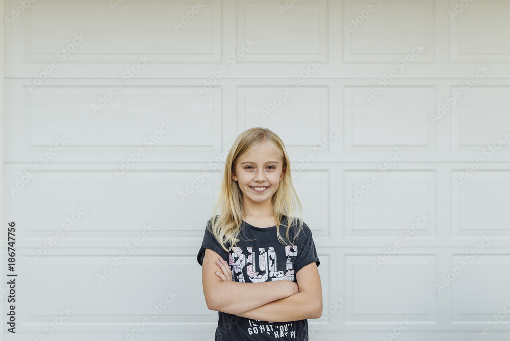 Portrait of girl with arms crossed standing against white wall Portrait of girl with arms crossed standing against white wall