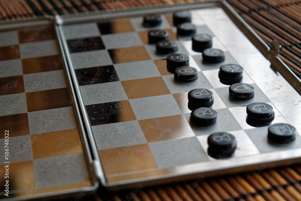 Photo with a picture of a chess steel Board and chess pieces, Metal chess pieces on a chess Board with reflection Photo with a picture of a chess steel Board and chess pieces, Metal chess pieces on a chess Board with reflection