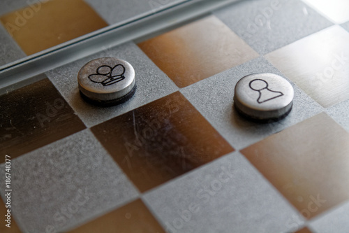 Photo with a picture of a chess steel Board and chess pieces, Metal chess pieces on a chess Board with reflection