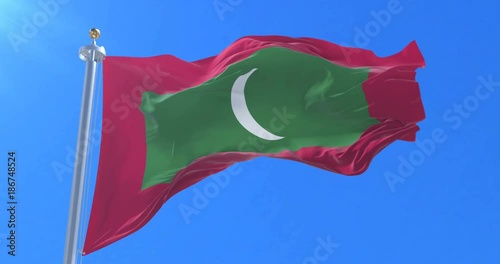 Flag of the Maldives waving at wind with blue sky in slow, loop photo