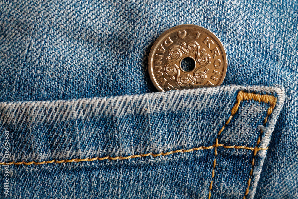 Denmark coin denomination is 1 krone (crown) in the pocket of old blue worn denim jeans Denmark coin denomination is 1 krone (crown) in the pocket of old blue worn denim jeans