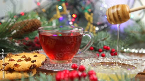 a cup of tea with honey and cookies, a branch of a Christmas tree in the snow, Christmas lights