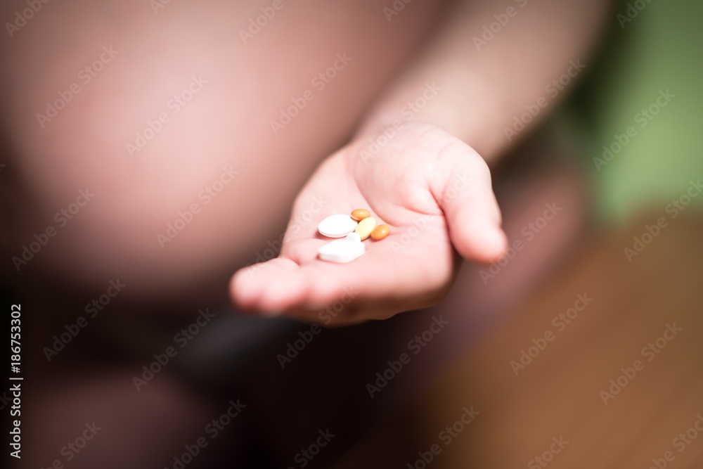 Medicine in capsules. Woman hands with pills on spilling pills out of bottle