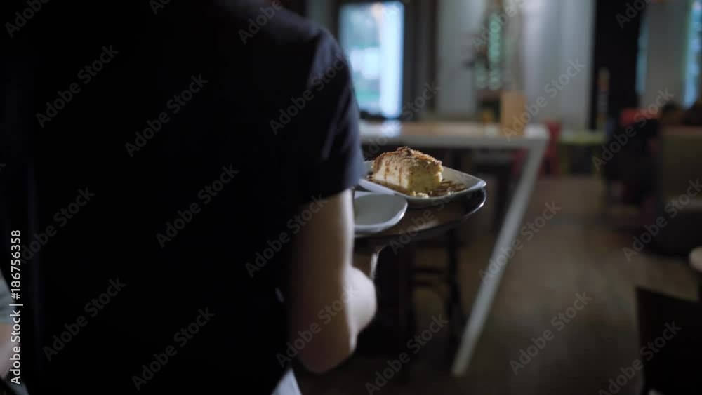 A close shot at the waiter's hand, who bears visitors their sweet desserts and cocktails, in a public place good service A close shot at the waiter's hand, who bears visitors their sweet desserts and cocktails, in a public place good service