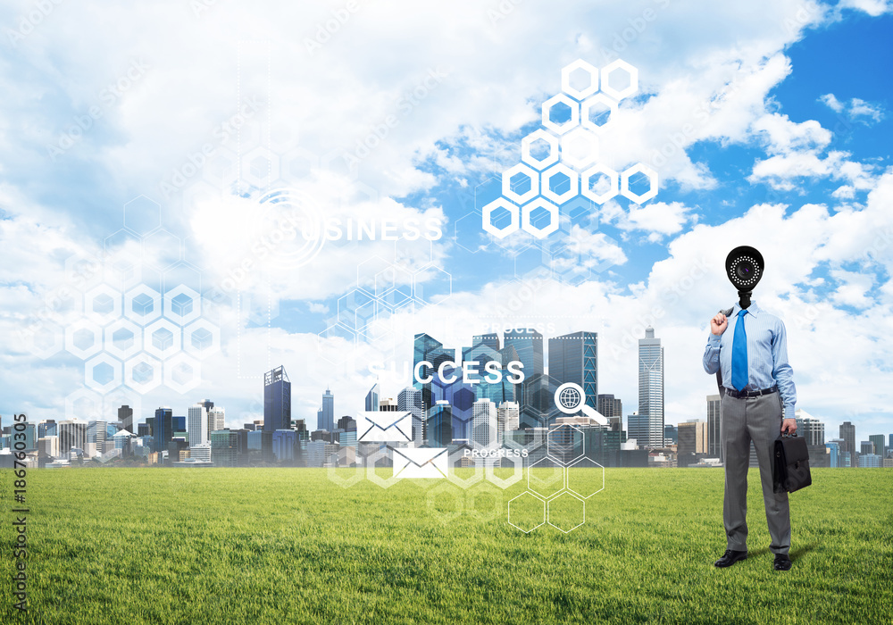 Camera headed man standing on green grass against modern cityscape Camera headed man standing on green grass against modern cityscape