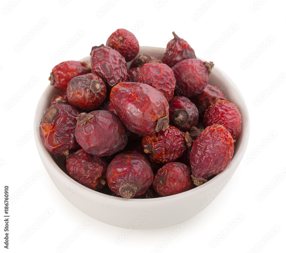 Ceramic white bowl with dried rose hip berries. Dried fruit. Isolated on white, close-up, top view. Ceramic white bowl with dried rose hip berries. Dried fruit. Isolated on white, close-up, top view.