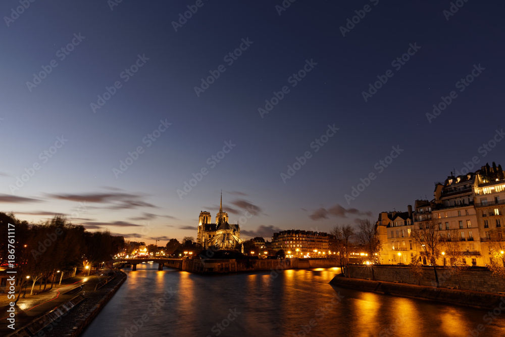 Notre dame de Paris by night and the seine river in the city of Paris in france