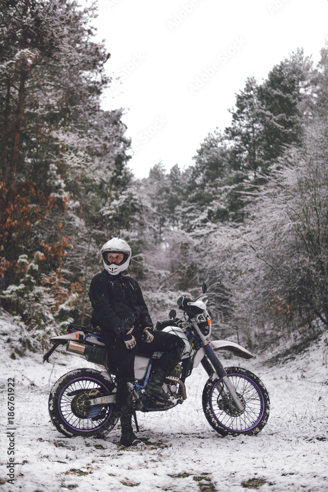 Rider man on a motorcycle Winter motocross. Skid on a snowy forest. the snow from under the wheels of a motorcycle Enduro. off road dual sport travel tour, active life style concept vertical Rider man on a motorcycle Winter motocross. Skid on a snowy forest. the snow from under the wheels of a motorcycle Enduro. off road dual sport travel tour, active life style concept vertical