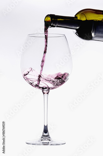 Pouring from wine bottle into an elegant crystal glass