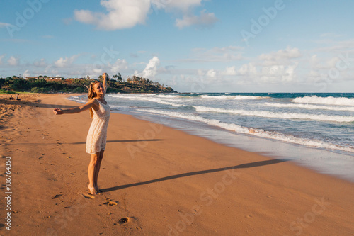 Young girl running down the beach in a swimming suite on the island of Kauai photo