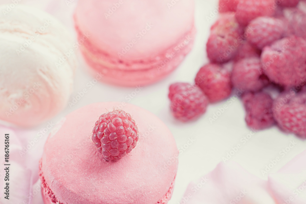 Pink raspberry macaroons with ripe raspberries. Selective focus. Dessert close-up