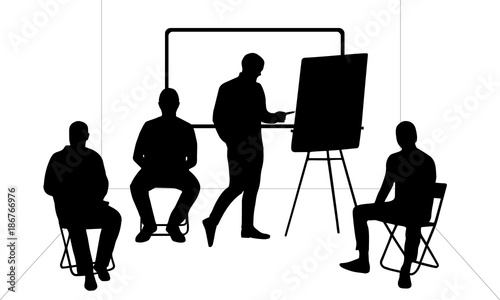 4 male silhouettes in the meeting room, 3 sitting, 1 writing on a flip chart
