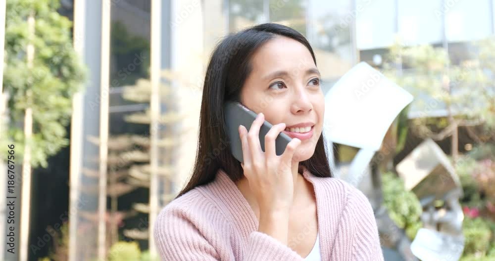 Woman talk to mobile phone outside shopping mall Woman talk to mobile phone outside shopping mall