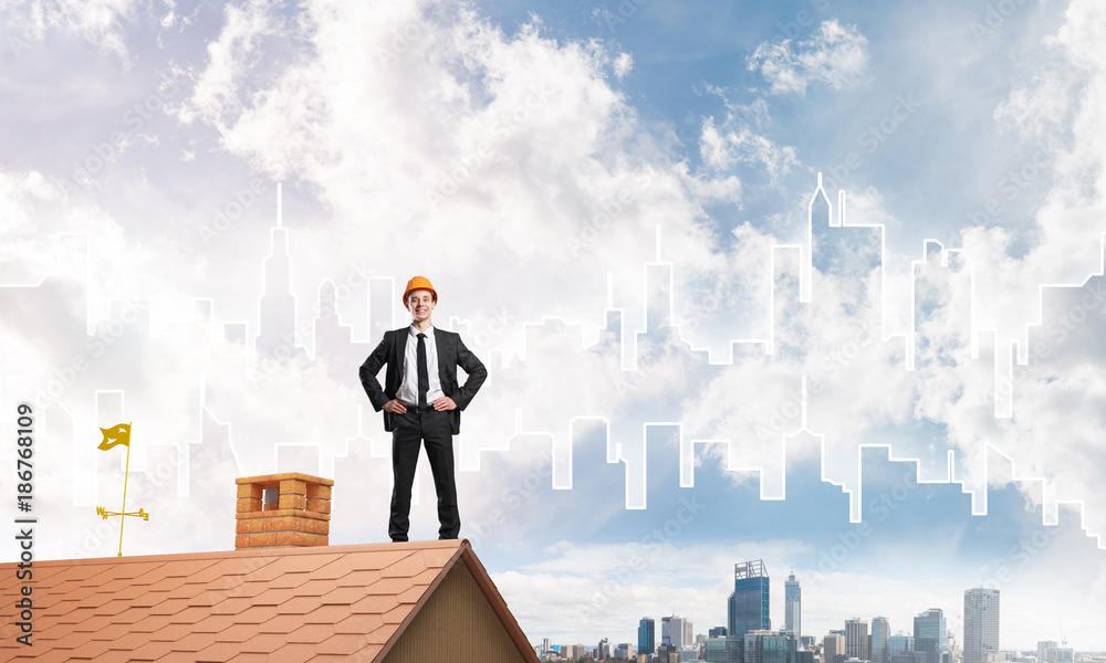 Engineer man standing on roof and looking away. Mixed media Engineer man standing on roof and looking away. Mixed media