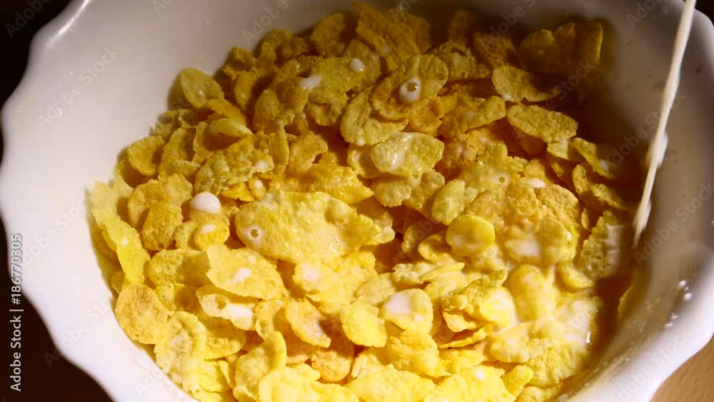 Milk pouring into bowl of corn flakes slowmo Milk pouring into bowl of corn flakes slowmo