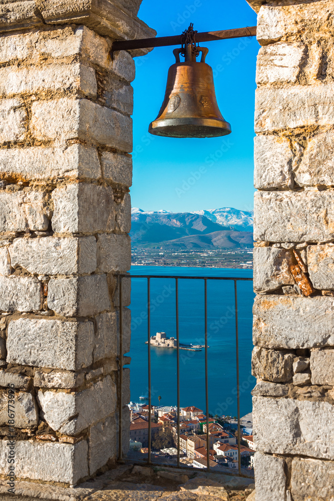 Obraz premium Old town of Nafplion in Greece view from bell tower, with tiled roofs, small port and bourtzi castle on the Mediterranean sea water