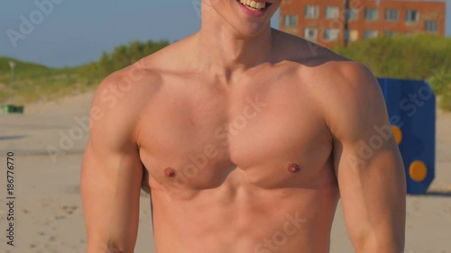 Smiling and happy fitness model on the beach
