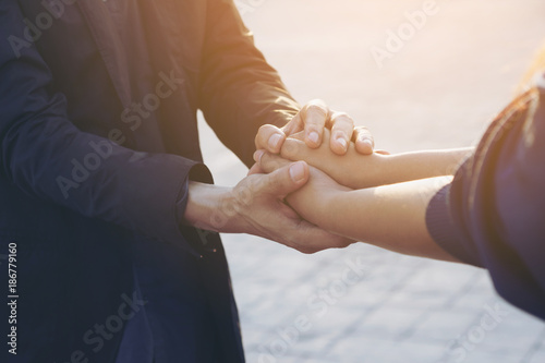 Close up on a man and a woman holding hands in the park photo